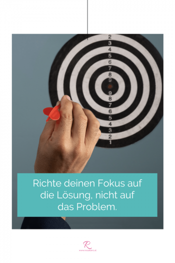 Es wird mit Pfeil auf Dartscheibe gezielt. Zitat-Text: "Richte Deinen Fokus auf die Lösung, nicht auf das Problem."